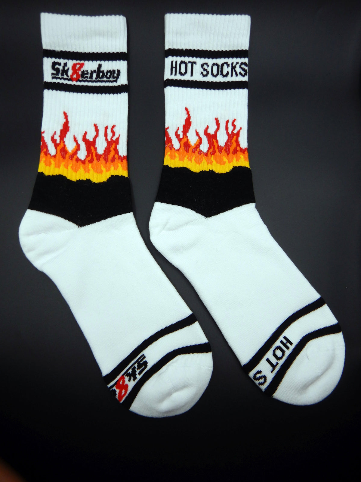 sk8erboy hot socks mit flammen bild auf der ferse in rot orange und gelb in detailansicht mit logo am bund und der unterseite