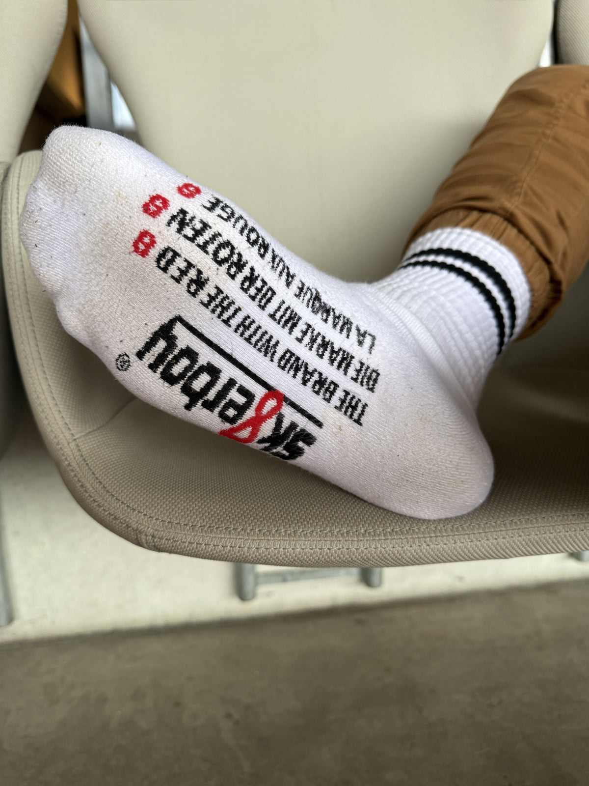 Moment de stade décontracté : chaussettes rétro Sk8erboy® à rayures noires et imprimé accrocheur sous la semelle, associées à des Nike Air Force 1 blanches – look streetwear stylé et plein d’attitude.