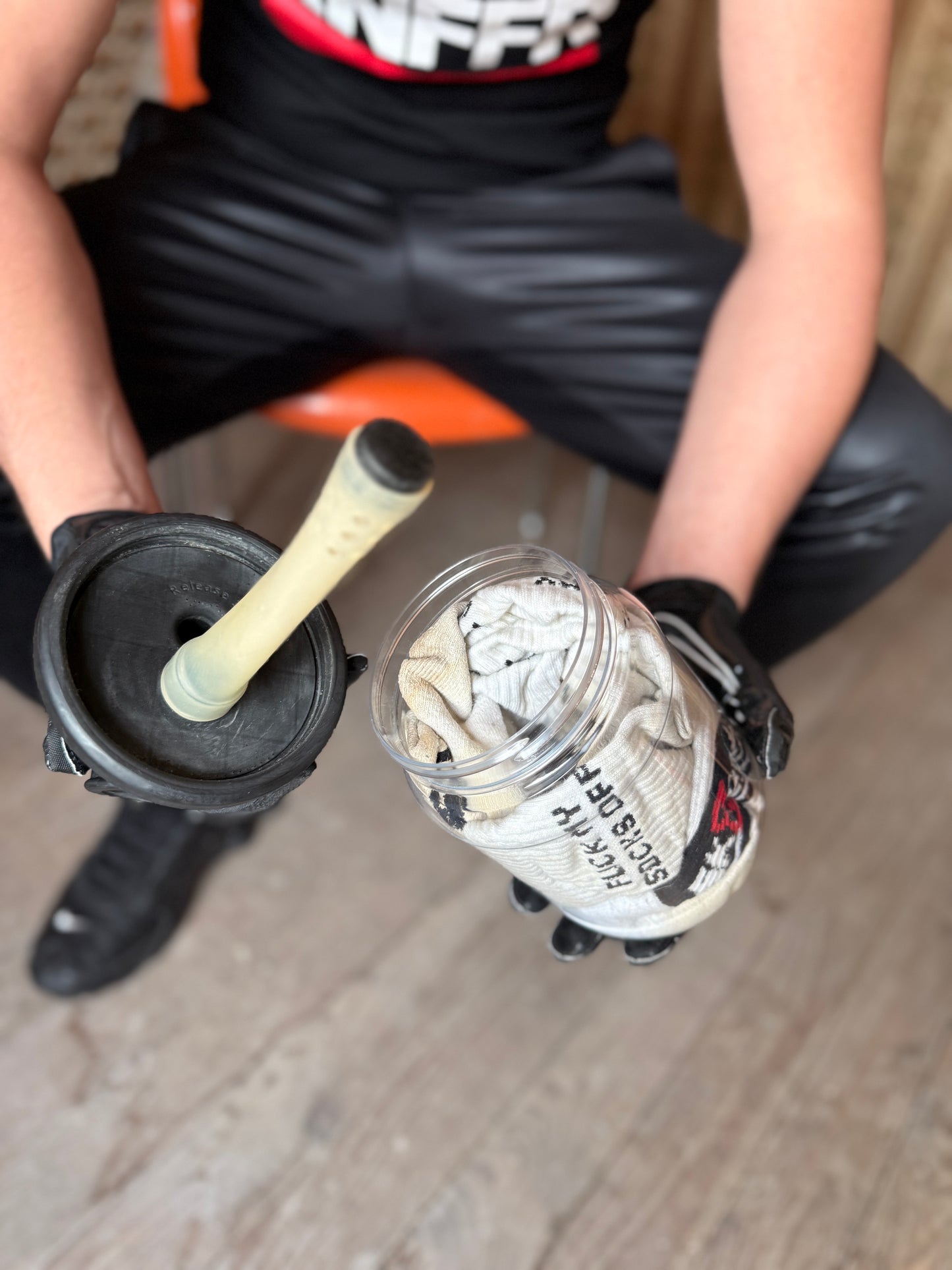 Person in schwarzer Hose und Handschuhen hält offenes Sk8erboy Vast Sniffer Glas mit Sockenfüllung und Filtereinsatz.