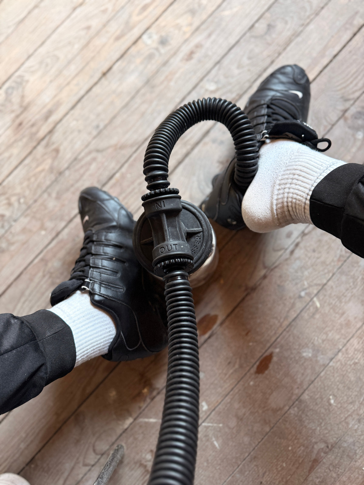 Zwei Feet in schwarzen leder shox und weißen Socken und sk8erboy mit verbundenem Vast Sniffer Schlauch auf Holzboden.
