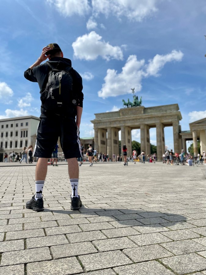 junger gay in berlin mit sk8erboy berlin socken und nike tn sneaker in kurzer short vor dem brandenbuger tor