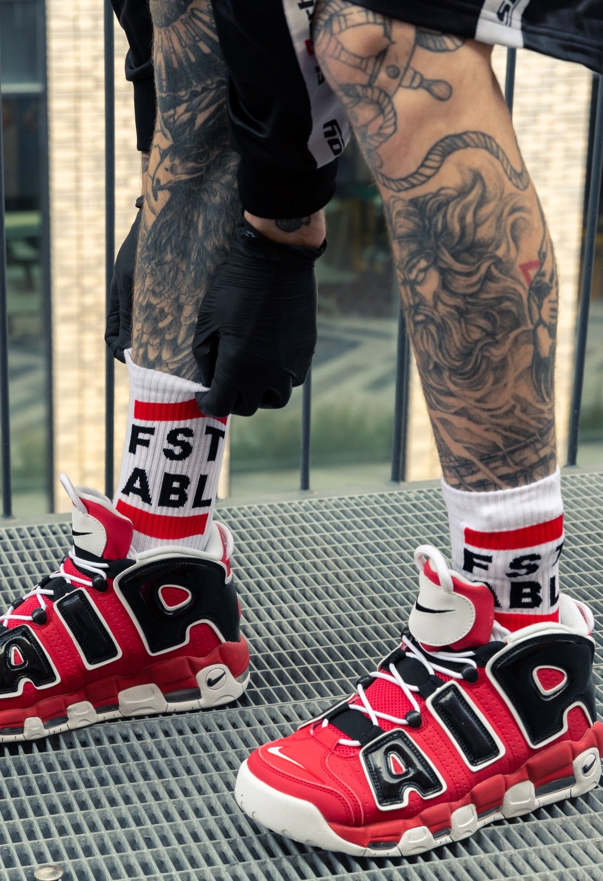 alt
Close-up of red Nike Air Max sneakers with FST ABL socks by sk8erboy on tattooed legs