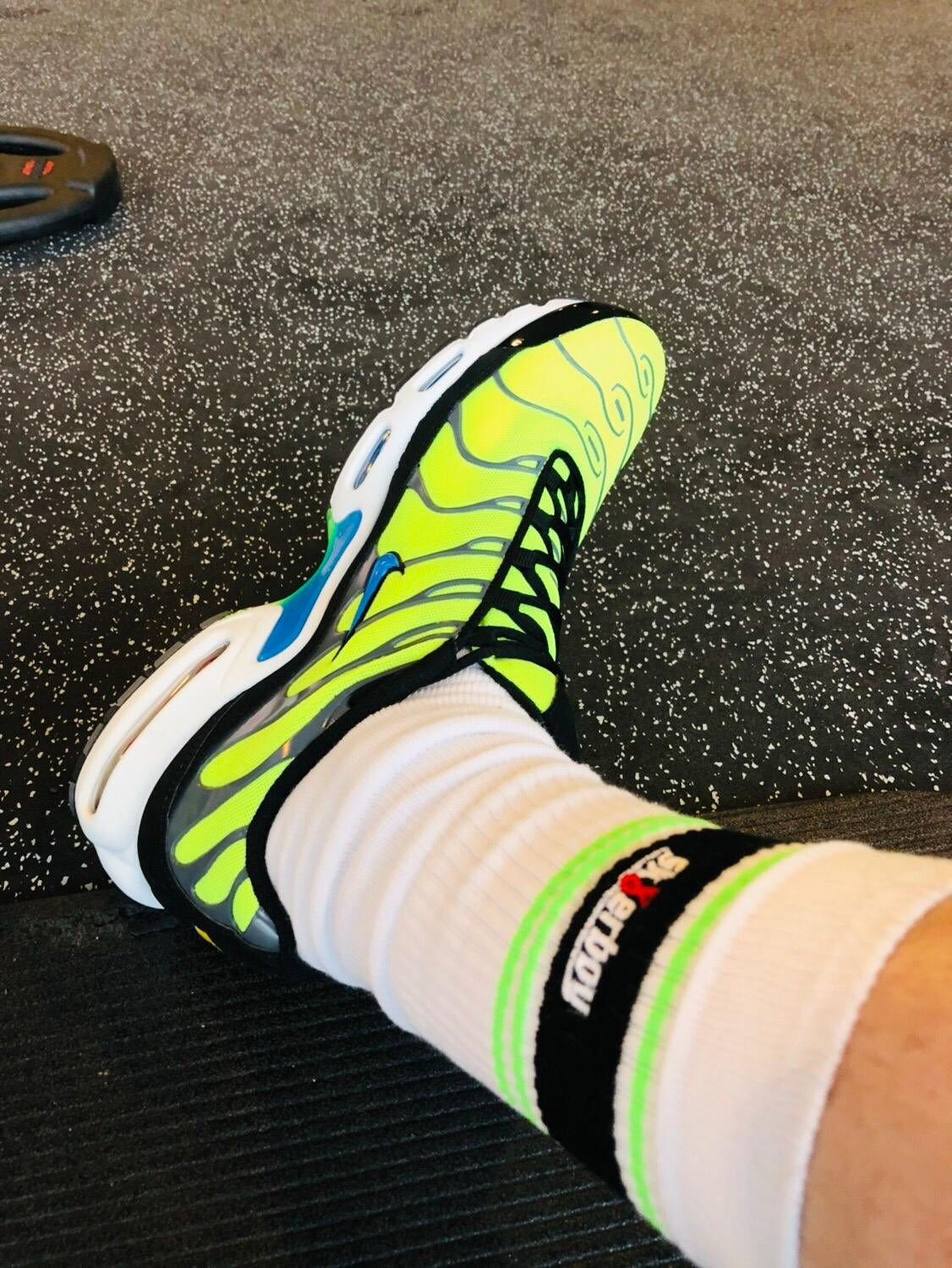 sk8erboy deluxe socks in neon gruen mit nike tn sneaker auf einem schwarzen boden im fitnessstudio gym