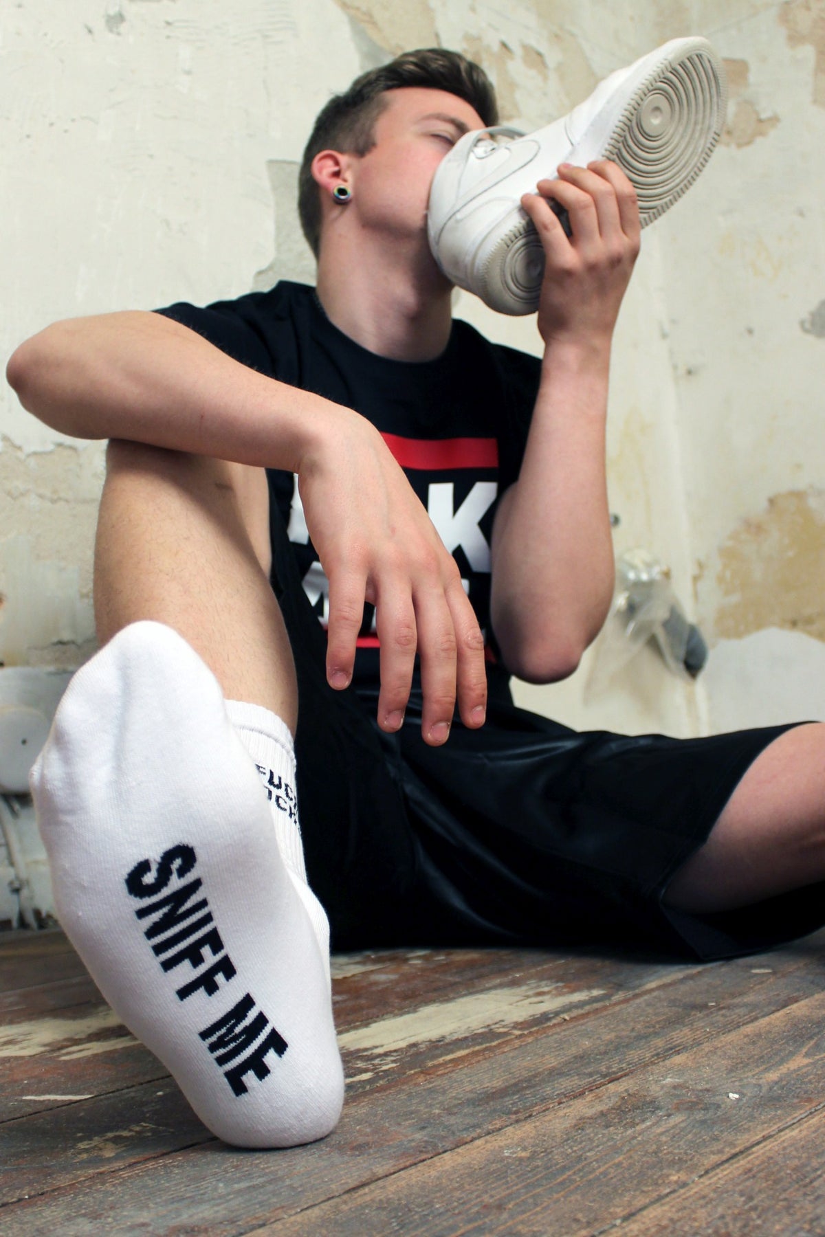 sk8erboy sniff me socks black socks with a bold black print on the white socks, wearing a sk8erboy fck abl t-shirt and sniffing his Nike Airs