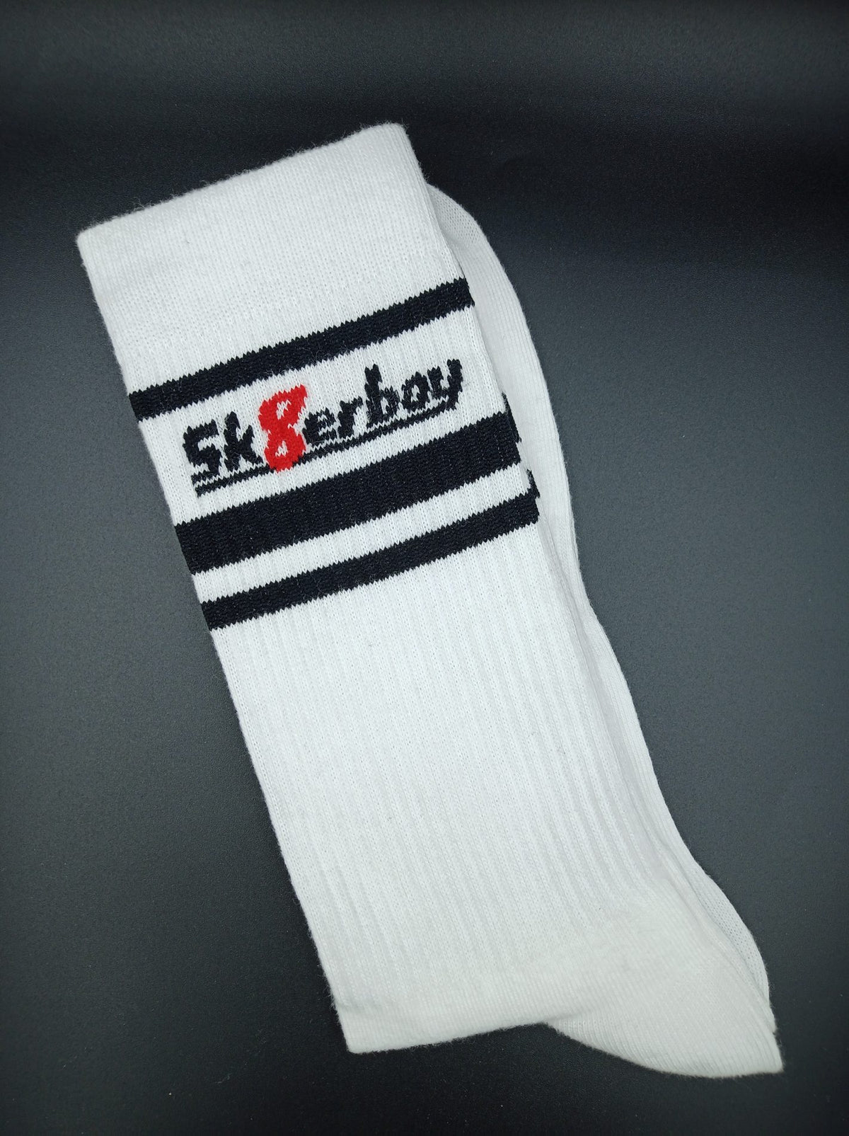 chaussettes sk8erboy victory extra fines, de qualité reconnue, particulièrement légères et idéales pour l’été, en blanc, avec gros plan sur la bordure avec logo sk8erboy