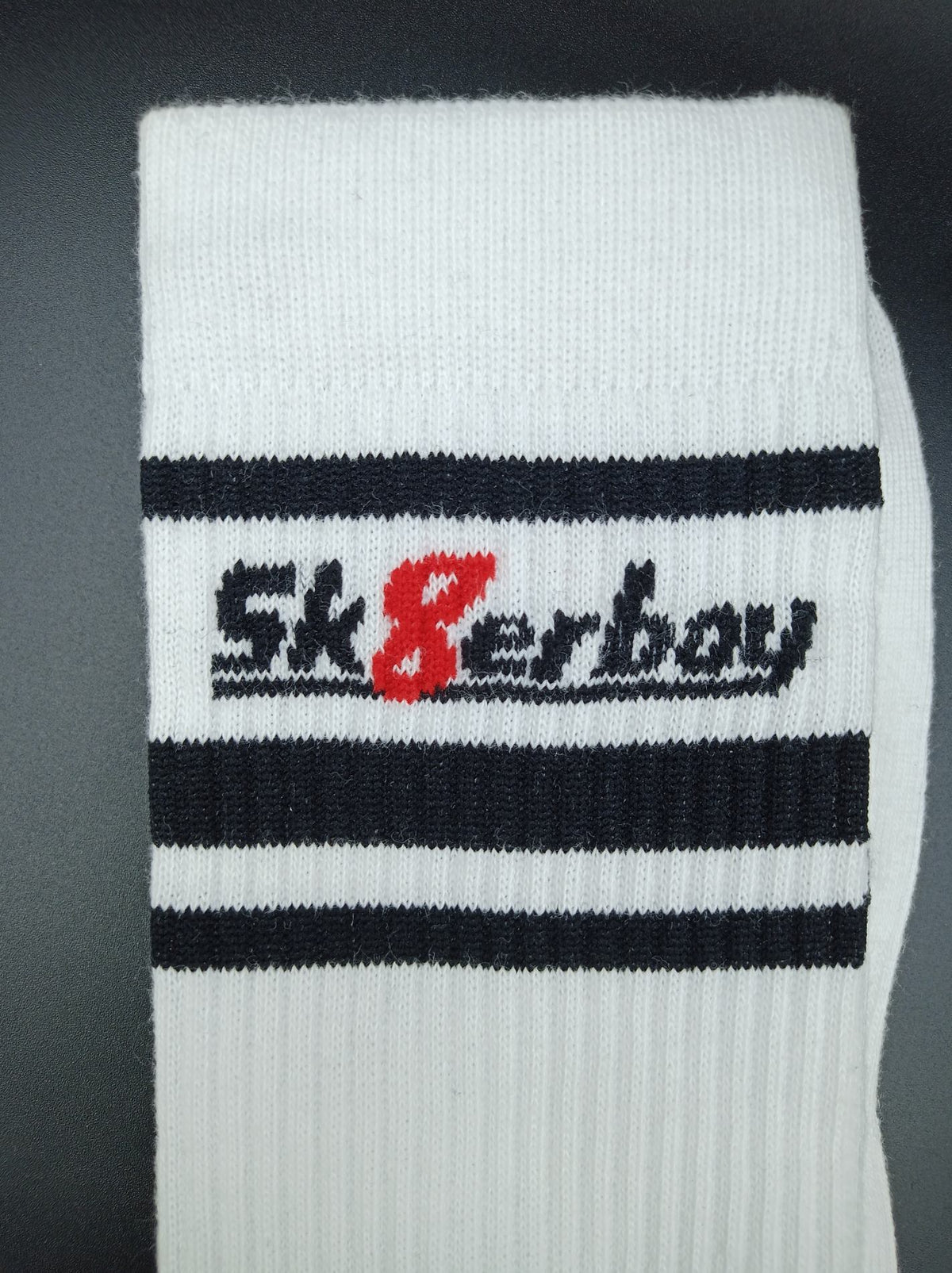 chaussettes sk8erboy victory extra fines, de qualité reconnue, particulièrement légères et idéales pour l’été, en blanc, avec gros plan sur la bordure et grand logo sk8erboy