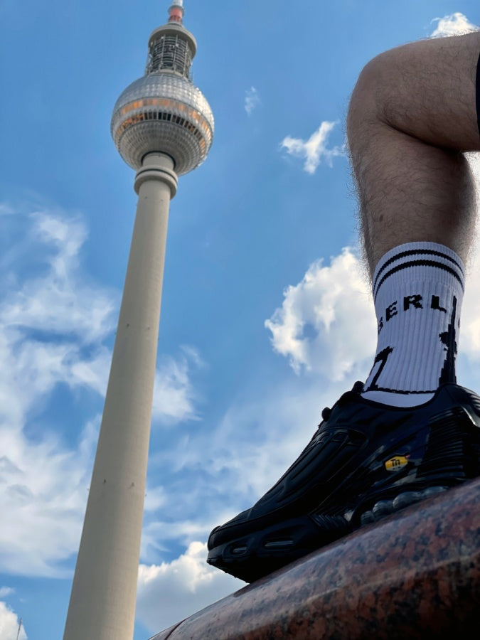 junger gay in berlin mit sk8erboy berlin socken und nike tn sneaker in kurzer short vor dem fernsehturm