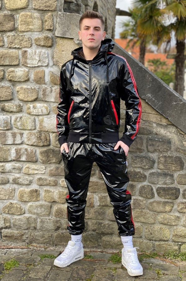 junger gay trägt einen glänzenden fetisch pvc trainingsanzug von mr riegillio in schwarz mit roten streifen mit sk8erboy sniff me socks und nike sneaker in weiss