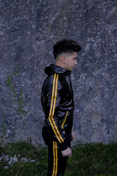 MR Riegillio PVC Tracksuit jacke mit gelben streifen von einem jungen gay getragen in schwarz glänzend mit passender hose von der seite