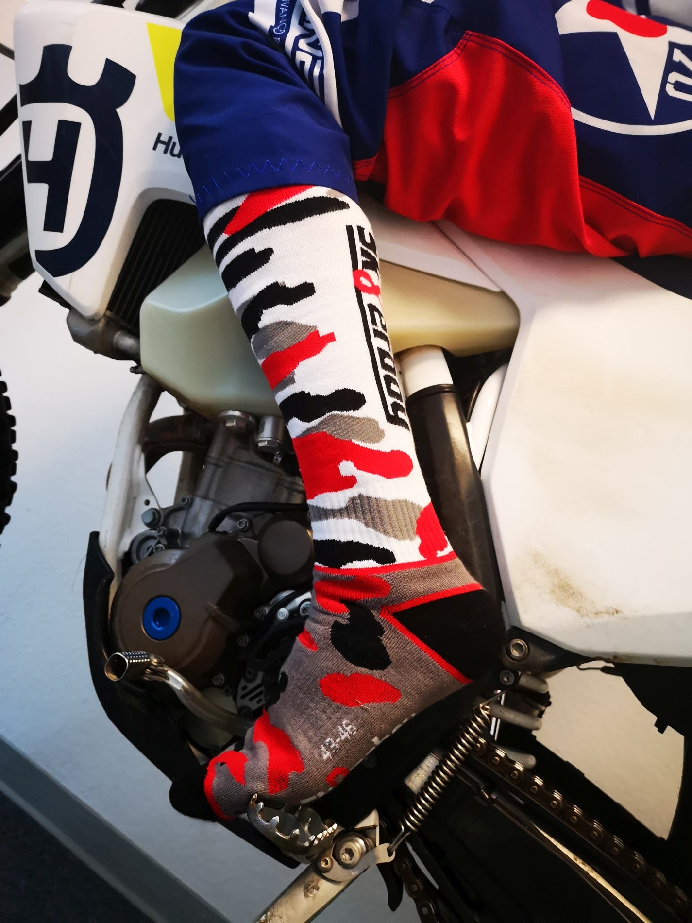 motorrad mit mx socks von sk8erboy in schwarz weiss rot grauem flecktarn muster mit großem logo auf sohle und rueckseite