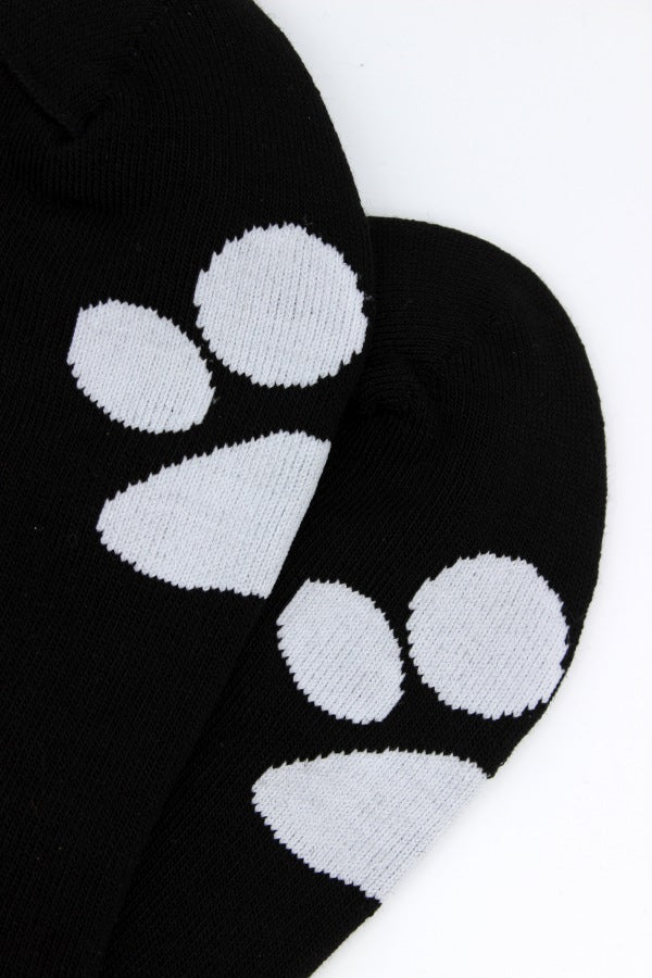 schwarze sk8erboy puppy socken mit weißer pfote an der seite und auf der sohle abgebildet mit verstecktem sk8erboy-logo auf der innenseite am bund detailansicht der hohen qualität